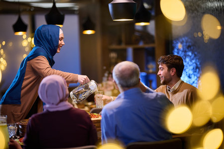 A modern and traditional European Islamic family comes together for iftar in a contemporary restaurant during the Ramadan fasting period, embodying cultural harmony and familial unity amidst a culinary celebration of diversityの写真素材