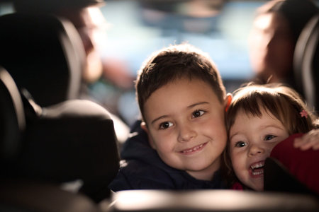 A young brother and sister enjoying a car ride together, immersed in the adventure of travelの写真素材