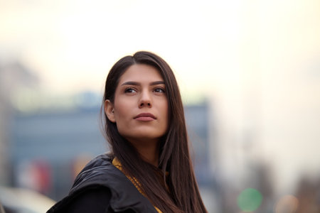 A beautiful woman poses for a portrait in an urban setting, exuding confidence and elegance amidst the bustling city environmentの写真素材