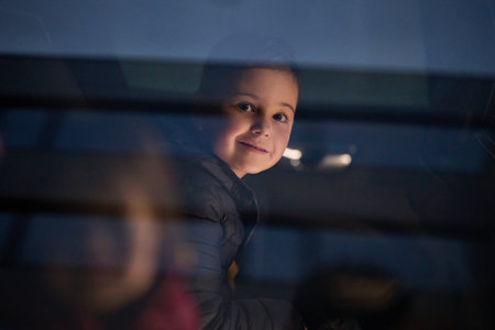 A young boy enjoys a car ride, captured through the window, as he observes the passing scenery.の写真素材