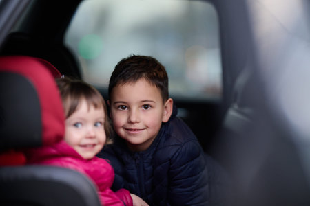 A young brother and sister enjoying a car ride together, immersed in the adventure of travelの写真素材