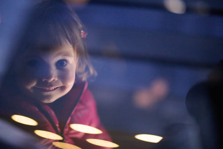 A young girl sits comfortably in a modern car seat, secured and ready for a family adventure on the...