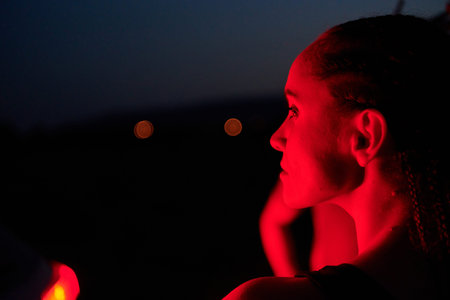 Athlete Strikes a Pose in Red-Lit Nighttime Glow