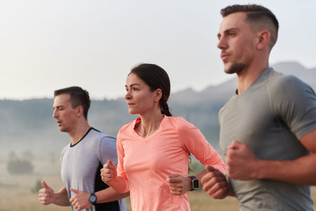 A group of friends, athletes, and joggers embrace the early morning hours as they run through the...