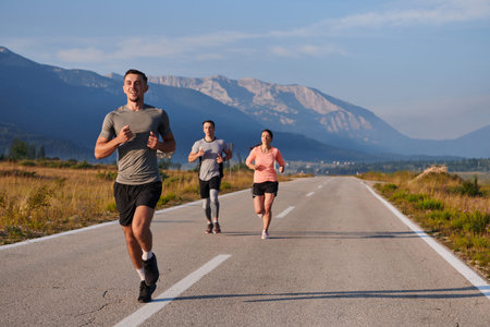 A group of friends maintains a healthy lifestyle by running outdoors on a sunny day, bonding over...