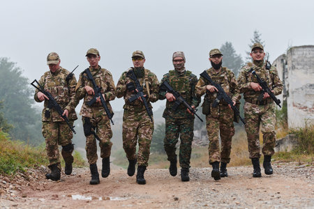 A disciplined and specialized military unit, donned in camouflage, strategically patrolling and...