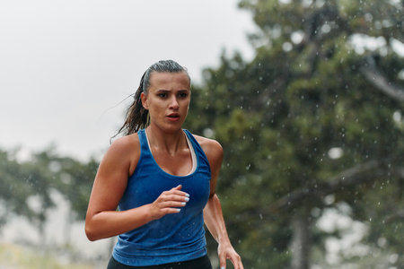 Unstoppable: A Determined Athlete Trains Through the Rain in Pursuit of Marathon Gloryの写真素材