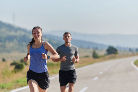 Energized by the beauty of nature, a couple powers through their morning run, their bodies and...