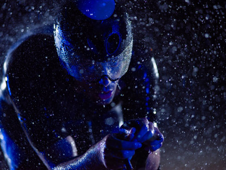 A triathlete braving the rain as he cycles through the night, preparing himself for the upcoming marathon. The blurred raindrops in the foreground and the dark, moody atmosphere in the background add to the sense of determination and grit shown by the athlete.の写真素材