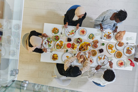 Top view of traditional and diverse Muslim family comes together to share a delicious iftar meal during the sacred month of Ramadan, embodying the essence of familial joy, cultural richness, and spiritual unity in their shared celebrationの写真素材