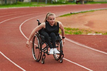 A woman with disablity driving a wheelchair on a track while preparing for the Paralympic Gamesの写真素材