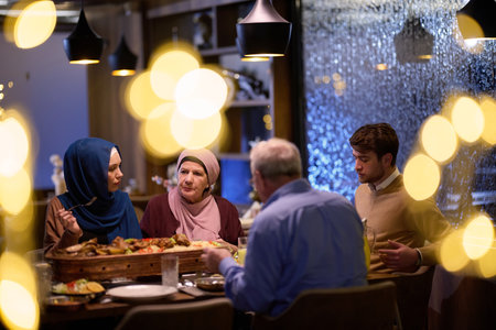 A modern and traditional European Islamic family comes together for iftar in a contemporary restaurant during the Ramadan fasting period, embodying cultural harmony and familial unity amidst a culinary celebration of diversityの写真素材