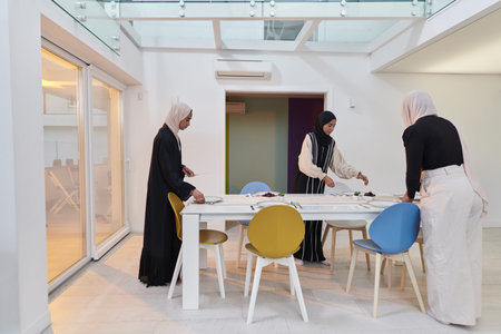 Group of young Arab women come together to lovingly prepare an iftar table during the sacred Muslim...