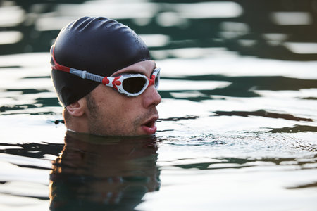 A triathlete finds serene rejuvenation in a lake, basking in the tranquility of the water after an intense training sessionの写真素材