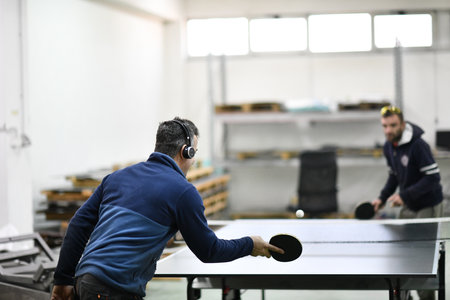 industry workers table tennis game and relaxing in their free timeの写真素材