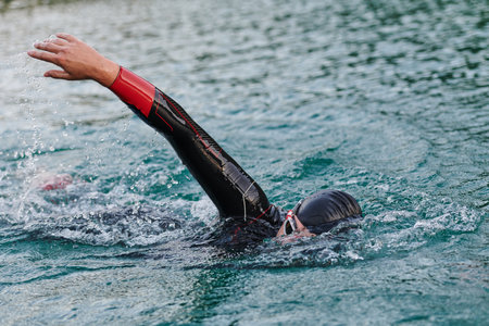 A professional triathlete trains with unwavering dedication for an upcoming competition at a lake, emanating a sense of athleticism and profound commitment to excellence.の写真素材