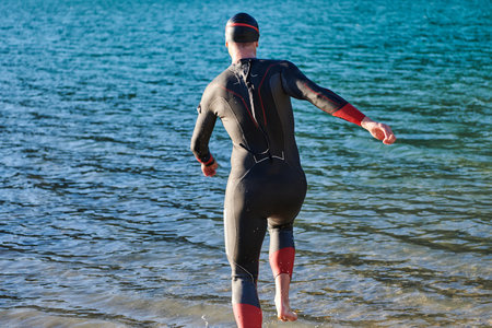 Triathlon athlete starting swimming training on lakeの写真素材