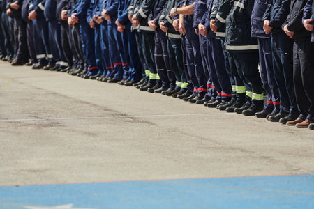 A group of firefighters lined up, saluting the flag, applauding in solidarity, and gearing up for...