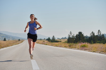 A determined woman athlete trains for success in the morning sun.の写真素材