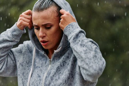 Woman Resting in the Rain After Intense Runの写真素材