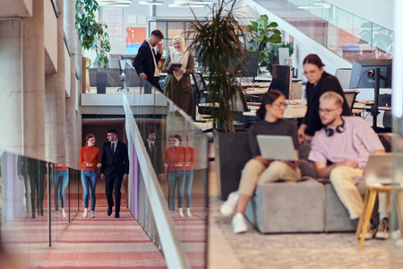 In a modern startup office, a diverse group of young professionals collaboratively tackles various business problems and challenges, surrounded by their engaged colleagues, fostering innovation and productivityの写真素材