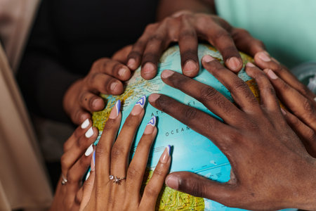 Close up of diverse teenagers hands delicately exploring a globe, capturing the essence of curiosity...