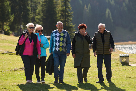 A family shares delightful moments with their friends amid the stunning landscapes of mountains, lakes, and winding paths, promoting a healthy lifestyle and the joy of familial bonds in the embrace of natures beautyの写真素材
