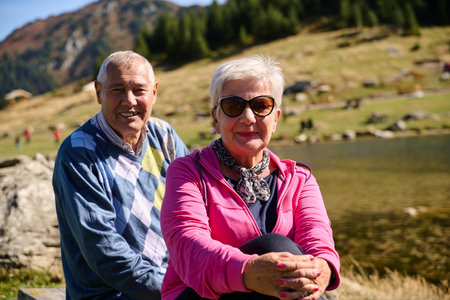 Elderly couple finding solace and joy as they rest on a park bench, engaged in heartfelt conversation, following a rejuvenating strol a testament to the enduring companionship and serene connection that accompanies the golden yearsの写真素材