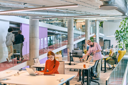 In a modern startup office, a diverse group of young professionals collaboratively tackles various...