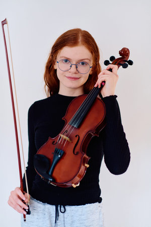 Stunning Redhead Musician Poses with Violin in Captivating Portraitの写真素材