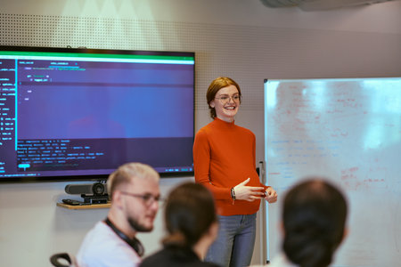 A pregnant business woman with orange hair confidently presents her business plan to colleagues in a modern glass office, embodying entrepreneurship and innovationの写真素材