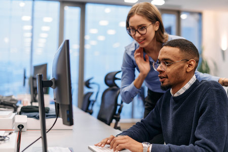 Digital Collaboration: Blonde Businesswoman and African American Partner Reviewing Documents Online