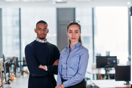 Dynamic Business Collaboration: Blonde Businesswoman and African American Colleague in Modern Office...