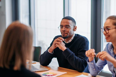 In the vibrant ambiance of a modern startup office, a diverse team of business professionals engage...
