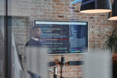 African-American businessman leads a meeting, passionately presenting a business plan to his attentive team, fostering collaboration and strategic thinkingの写真素材