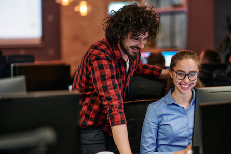 Business colleagues, a man and a woman, engage in discussing business strategies while attentively...
