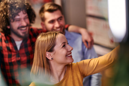A diverse group of business professionals take a break from their tasks in a modern startup office to capture a creative selfie, showcasing teamwork and a vibrant workplace cultureの写真素材