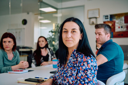 Diverse Business Team Discussing Projects in a Modern Glass Office.