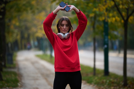 Athletic young woman taking a breath and relaxing after jogging and stretching. Woman Training and...