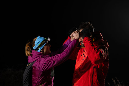 Runners tired of breathing after training look at their tech sports smart watch in night on maintainの写真素材