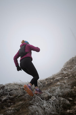 trail running woman athlete training for ultra-marathon race in a mountain