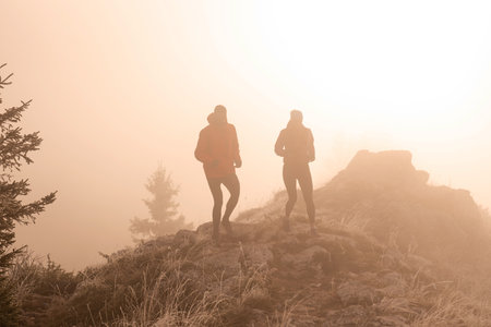 trail running couple man and woman running on a mountain pathの写真素材