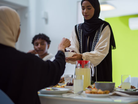 A woman in a hijab extends a platter of dates to her diverse family, creating a scene of unity and...