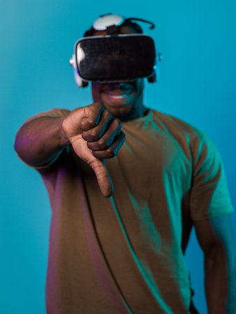 African American man, wearing virtual reality glasses, expresses dissatisfaction by pointing down...