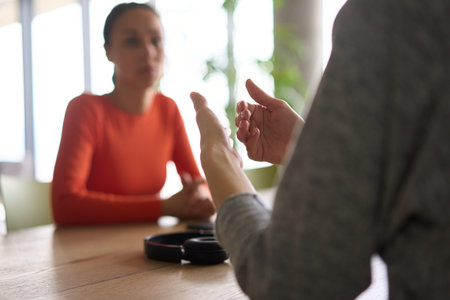 A young, diverse business team sitting together in a modern office, exchanging ideas and business plans, fostering collaboration and innovation for future success.の写真素材