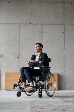 A director in a wheelchair sitting alone in an empty office, deeply reflecting on business strategies and decisions, contemplating the path forward with focused determination.の写真素材
