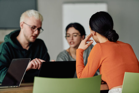 A diverse multiethnic business team engages in a collaborative meeting, discussing strategies and...