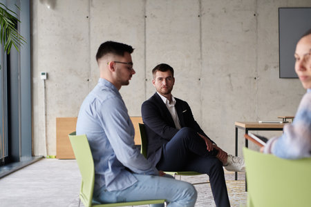 A diverse multiethnic business team engages in a collaborative meeting, discussing strategies and solutions in a modern office settingの写真素材