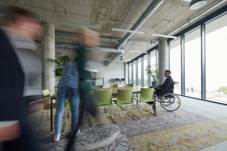 Business Team Led by Director in a Wheelchair Preparing for a Meeting in a Modern Office.の写真素材