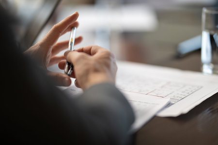 A businessman holding a pen thoughtfully during an important business meeting, ready to make key decisions.の写真素材